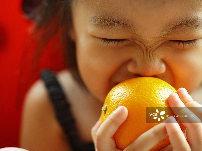 一个女孩咬橘子的特写图片素材