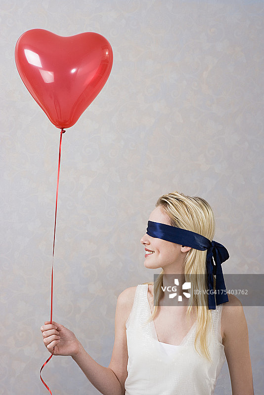 戴着气球的蒙住眼睛的女人图片素材