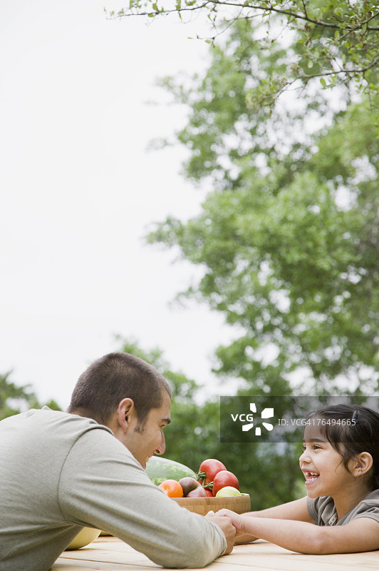 父亲和女儿坐在野餐桌旁图片素材