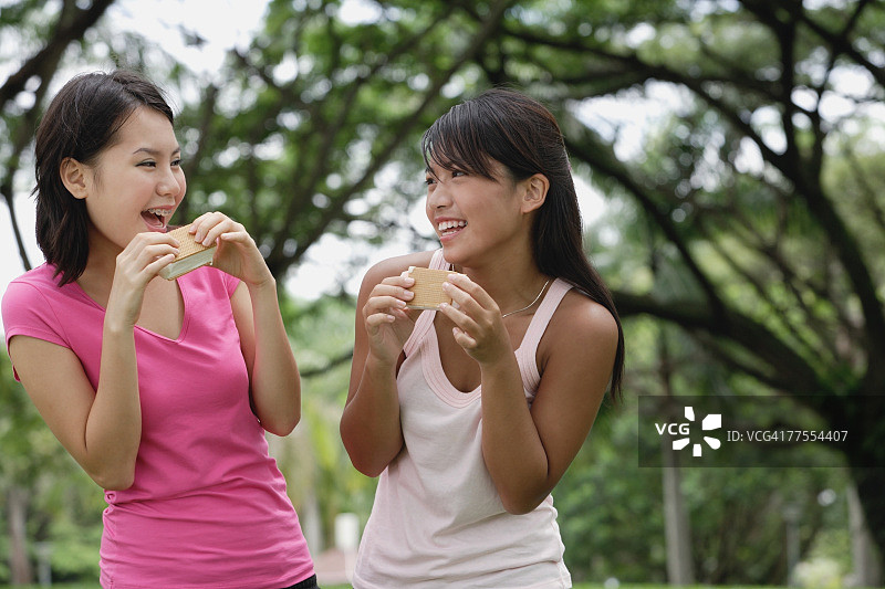 两个女人在吃冰淇淋，面带微笑图片素材