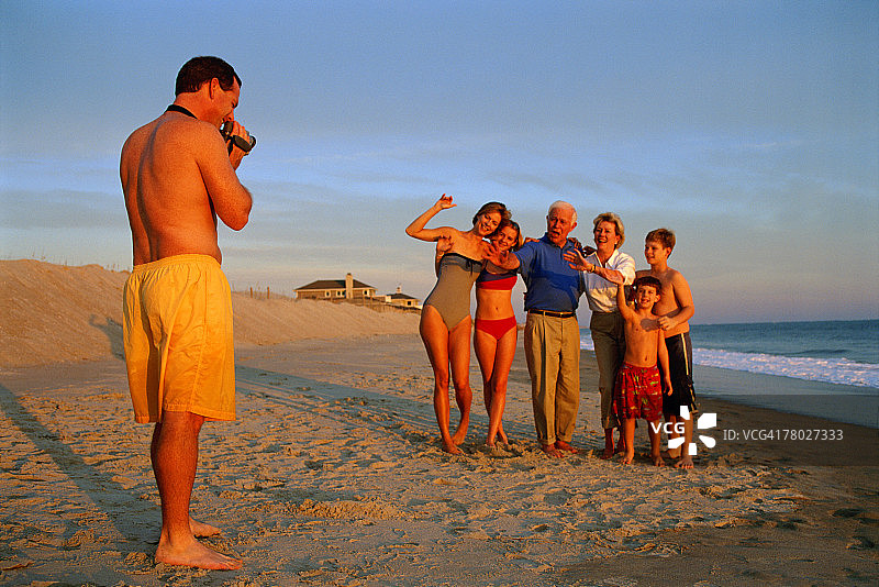 一名男子在海滩上拍摄家人图片素材