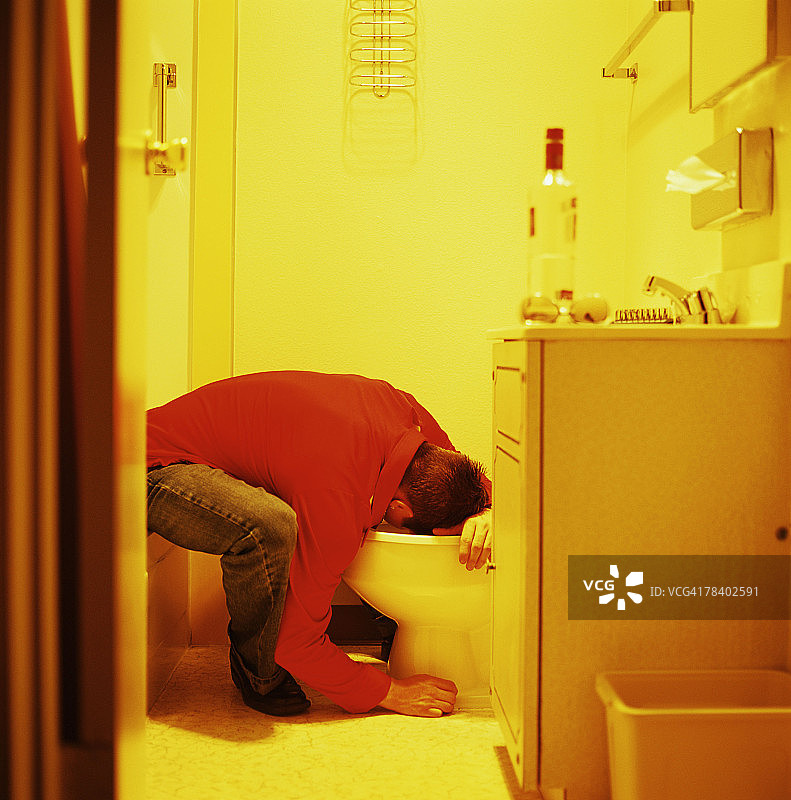 男子向厕所呕吐图片素材