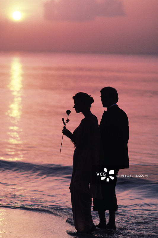 一对情侣站在海滩上的剪影图片素材