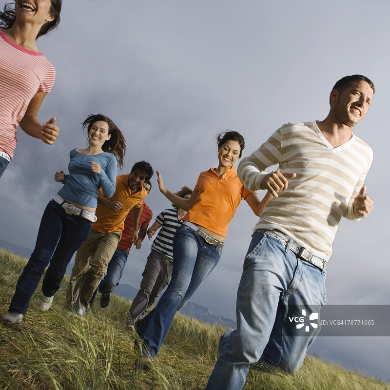 年轻人在草地上奔跑图片素材