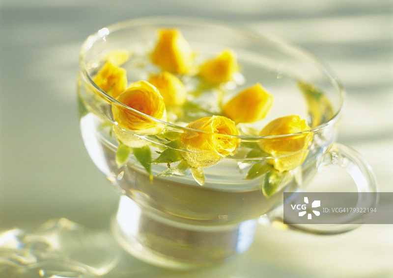 黄玫瑰漂浮在杯，高角度的观点，近，差焦点，在焦点，出焦点图片素材