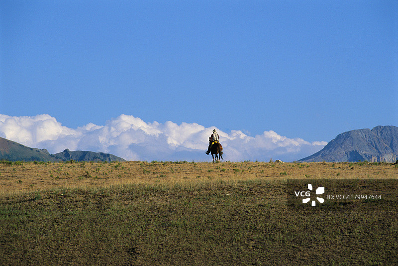牛仔骑马穿越平原图片素材