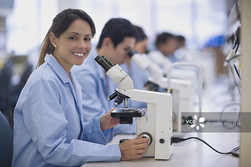 在实验室中使用显微镜工作的科学家图片素材