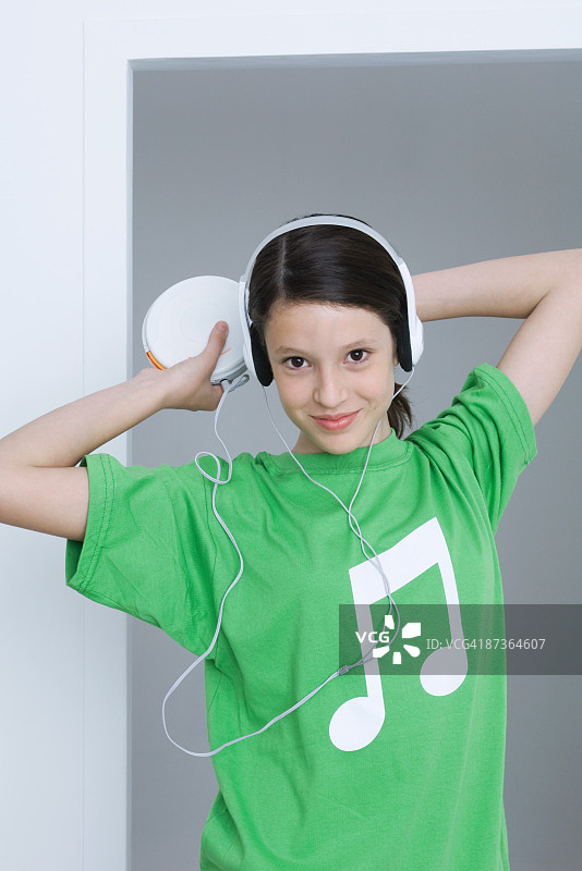 女孩听着便携式CD播放机，穿着印有音符的t恤图片素材