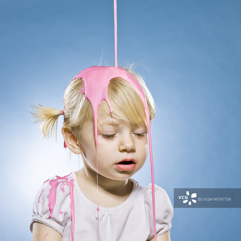 小女孩的头上被浇了粉红色的颜料图片素材