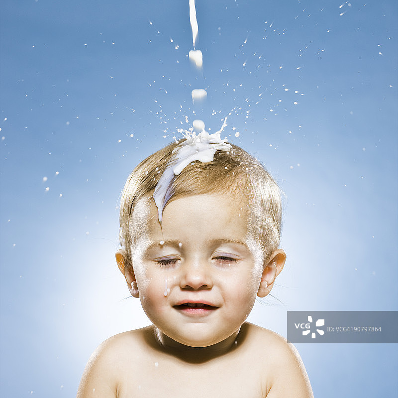 小男孩的牛奶倒在他的头上图片素材
