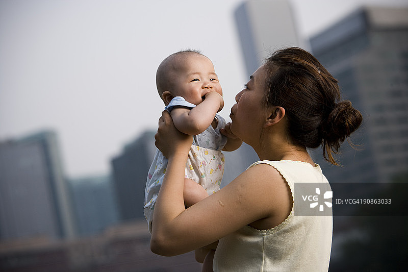 妇女抱着婴儿在户外微笑图片素材
