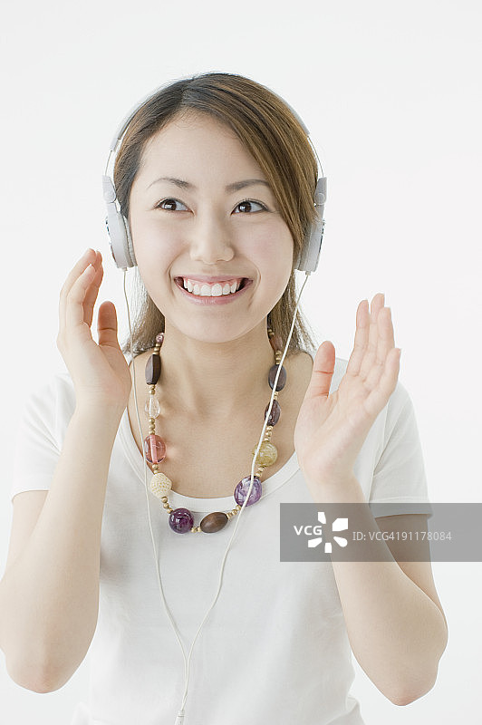 女人戴着耳机，面带微笑图片素材