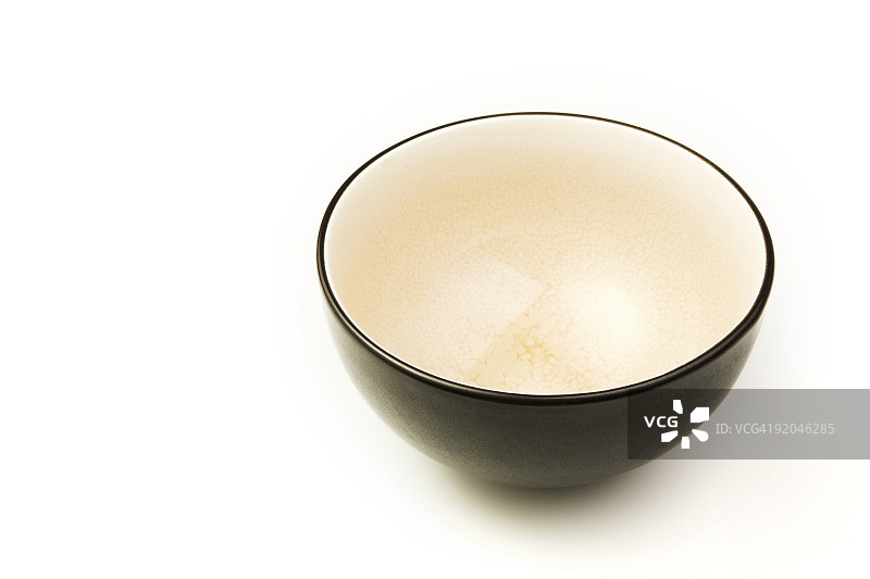 黑色陶瓷碗，奶油色内饰，白色背景图片素材
