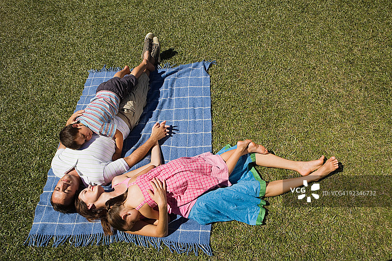 一家人躺在野餐毯子上图片素材