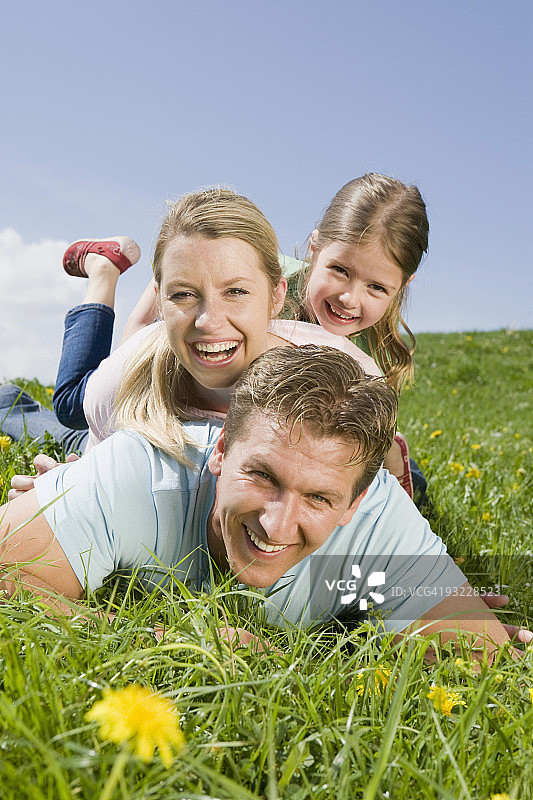 德国，巴伐利亚，慕尼黑，一家人躺在草地上，笑着，画像图片素材