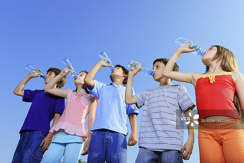五个孩子在喝瓶子里的水。图片素材