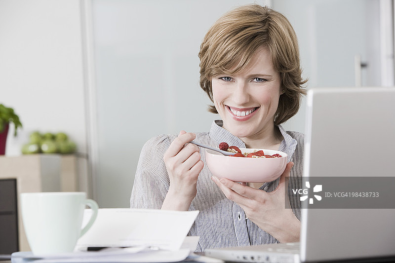 肖像女子在家电脑前吃零食图片素材