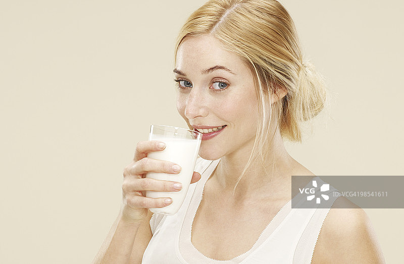 女人微笑着喝新鲜牛奶图片素材
