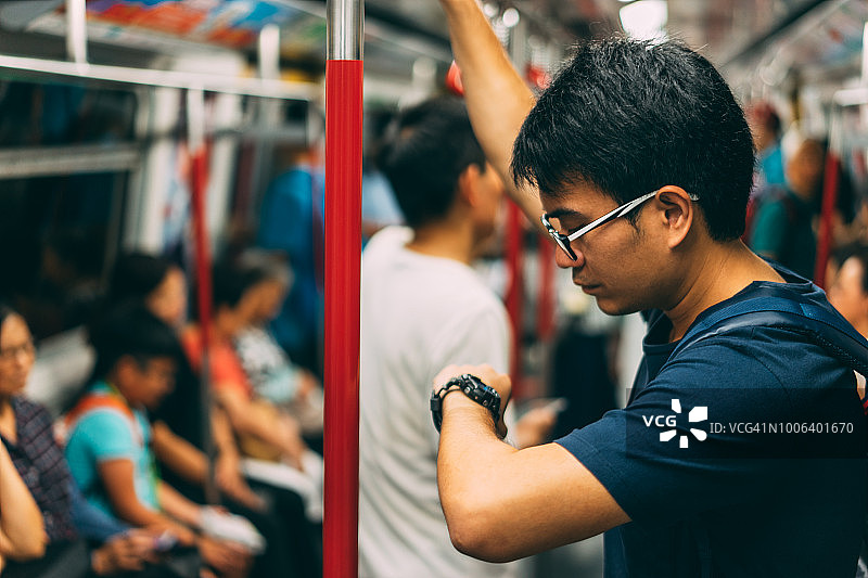 一个年轻的游客正在香港乘地铁参观和观看。地下铁路是香港的快速铁路系统。图片素材
