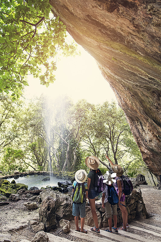 一家人徒步旅行看山上的瀑布图片素材