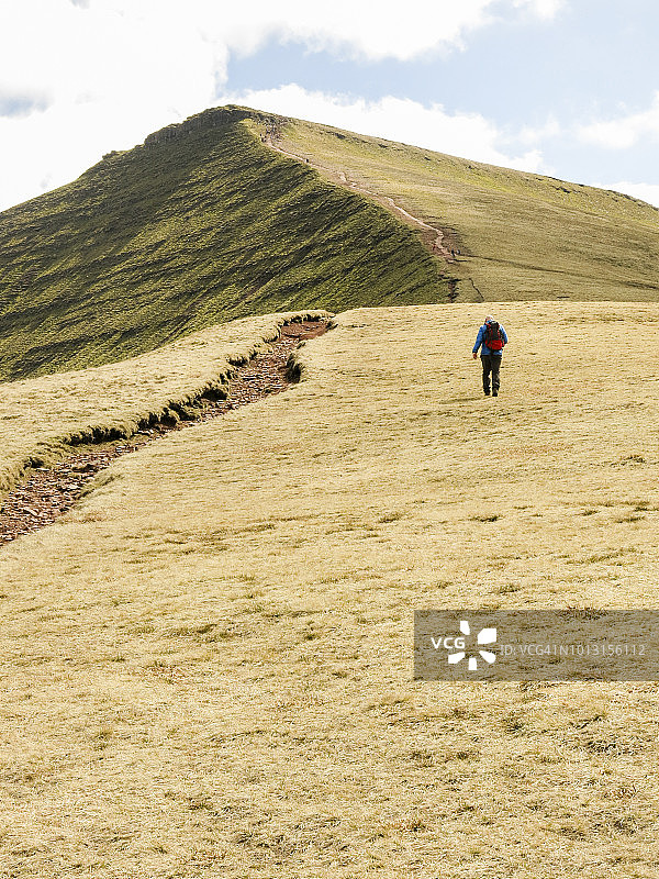 孤独的步行者爬上玉米杜;图片从圆形散步在布雷肯灯塔，威尔士，英国在玉米杜和Pen Y fan的顶峰。图片素材
