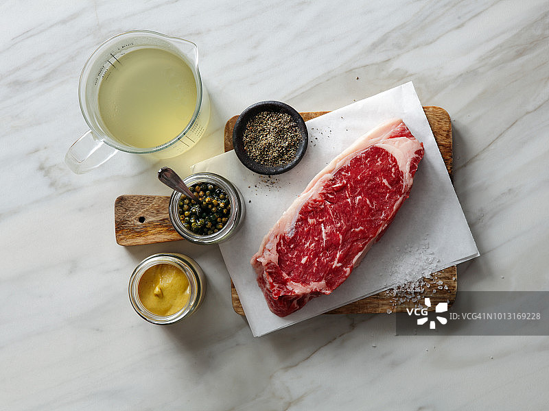 新鲜的生牛肉和配料烹饪在光的背景图片素材