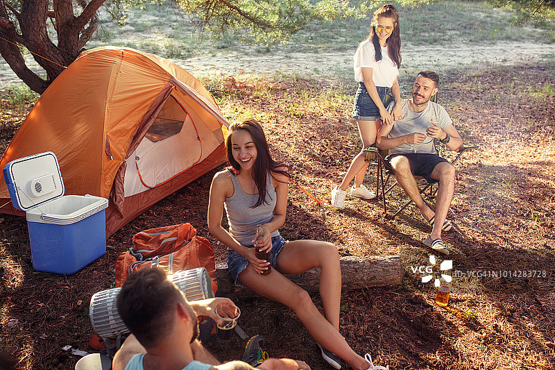 聚会，男女团体露营在森林。他们放松图片素材