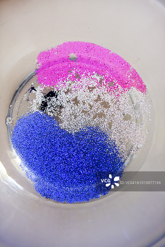 彩色的闪光和胶水在一个玻璃碗制作黏液图片素材