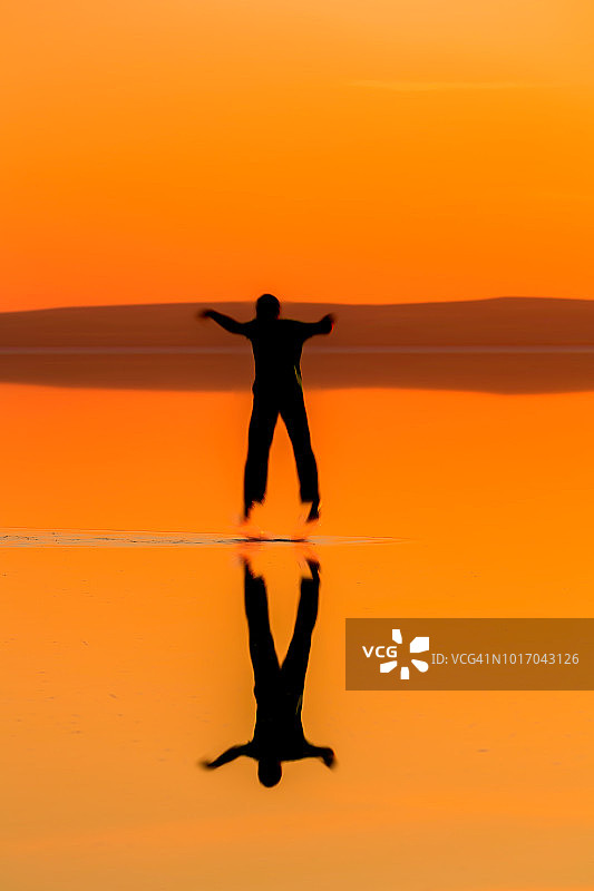 放松-剪影的跳跃男子在日落在土耳其盐湖-过滤图片素材