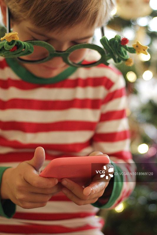 圣诞期间用智能手机的男孩图片素材