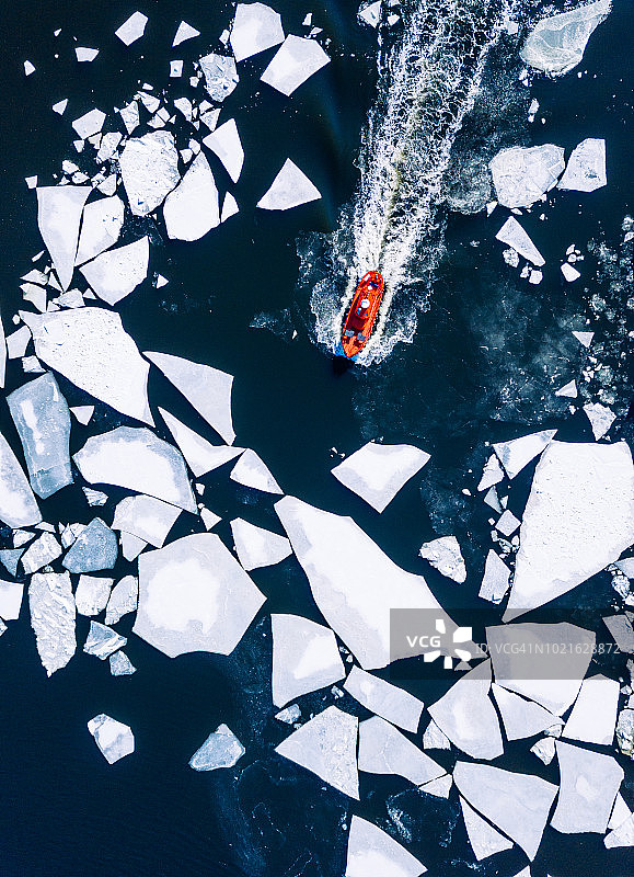 冬季自上而下的鸟瞰图，红色的破冰船在赫尔辛基周围的波罗的海推进破裂的冰图片素材