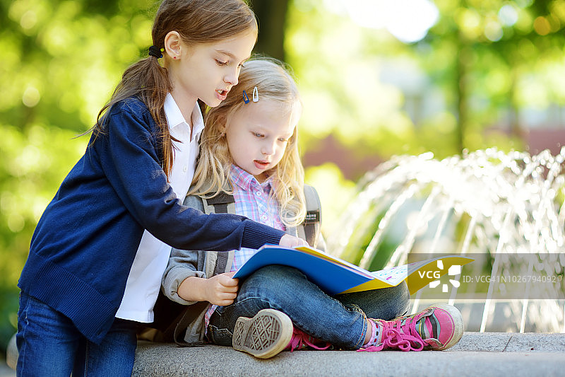 可爱的小女生在晴朗的秋日在户外学习。年轻的学生在做作业。对小孩子的教育。图片素材