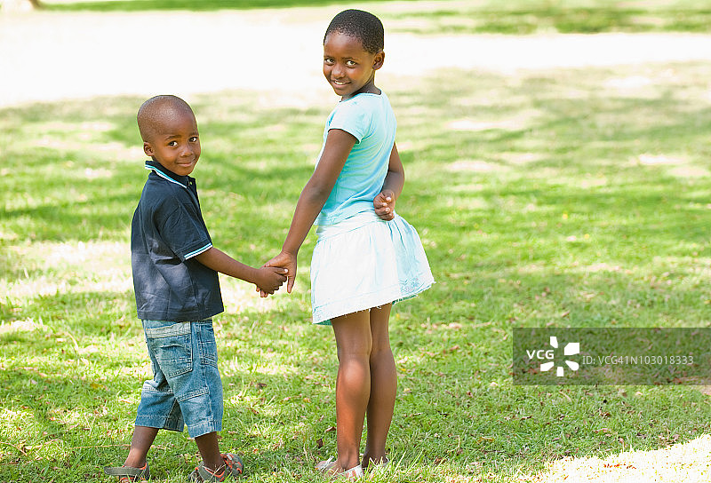 女孩和男孩的肖像(4-8)牵手在花园，约翰内斯堡，豪登省，南非图片素材