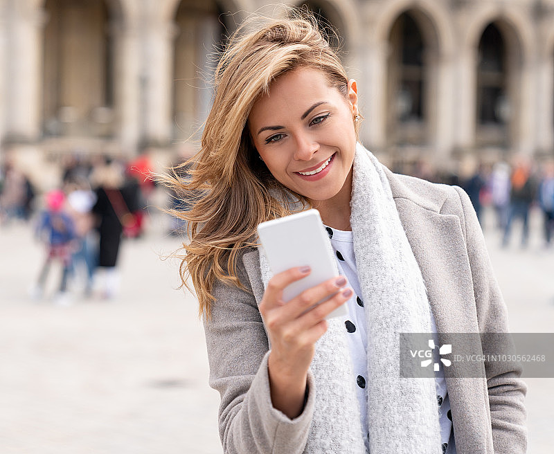 一个女人在街上用手机发短信图片素材