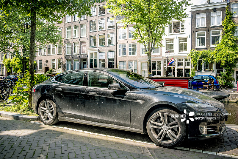特斯拉Model S全尺寸电动五门掀背车停在阿姆斯特丹运河附近。图片素材