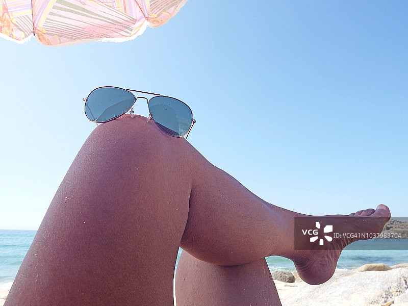 在海滩上剃须晒太阳的男人图片素材