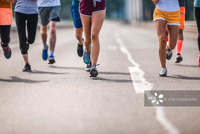 一群不知名的运动员在路上跑马拉松。图片素材