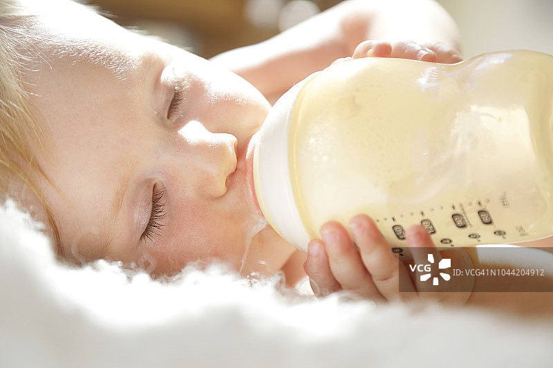 婴儿躺下喝着奶瓶图片素材