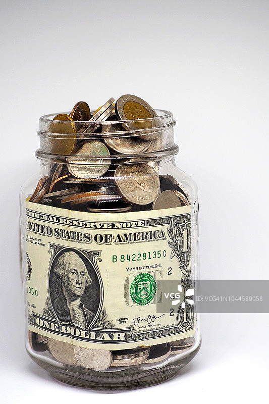 存钱罐里装满硬币，孤立在白色背景上图片素材