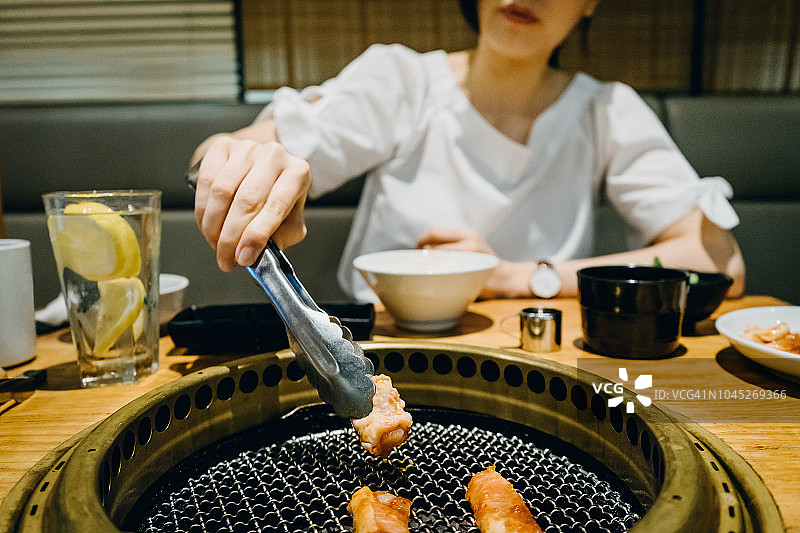 在餐馆吃传统日式牛肉烤肉的女人图片素材