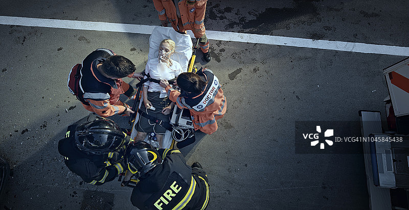 在事故现场，医护人员用担架稳定受伤妇女的身体图片素材
