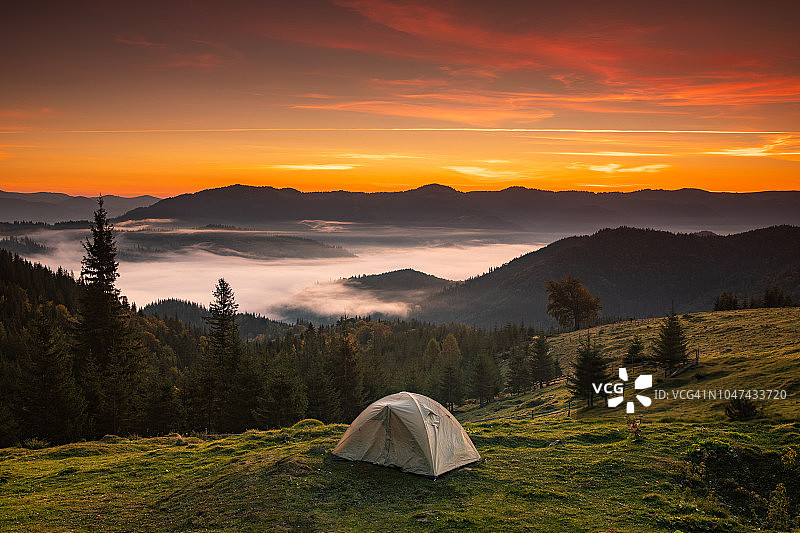 黎明时分在薄雾笼罩的群山中搭起帐篷图片素材