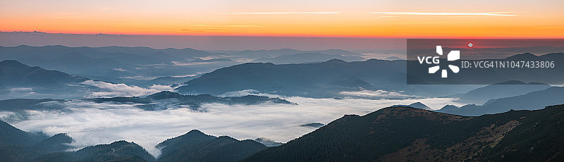 群山中雾蒙蒙的黎明全景。美丽的景观图片素材