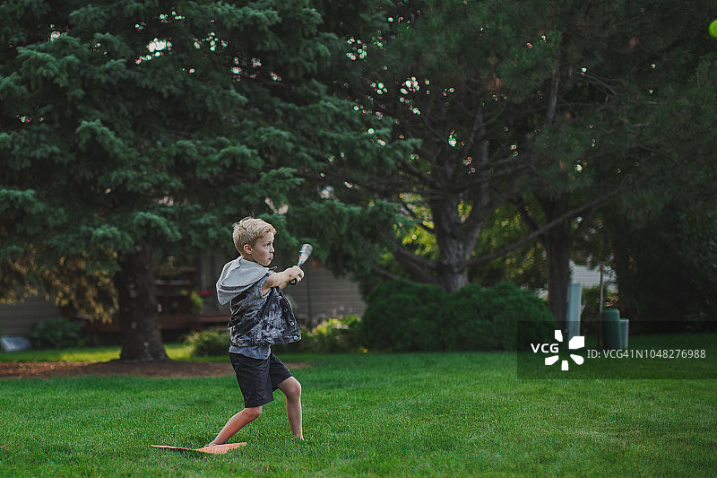 男孩在后院打棒球图片素材