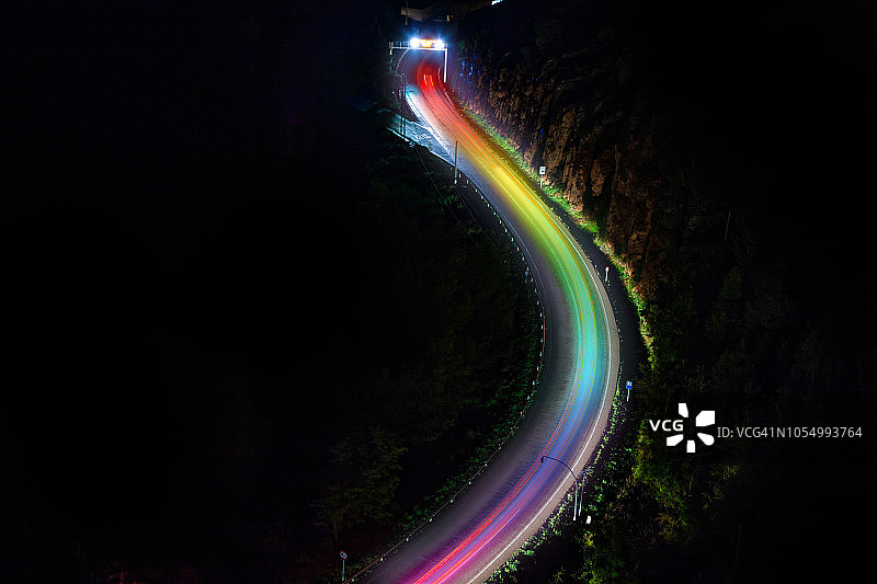 空中道路在夜晚与彩虹光trail效果。图片素材