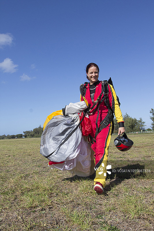 女跳伞运动员着陆后对着镜头微笑图片素材