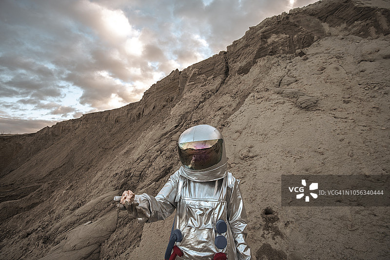宇航员在一个无名星球上采集岩石样本图片素材