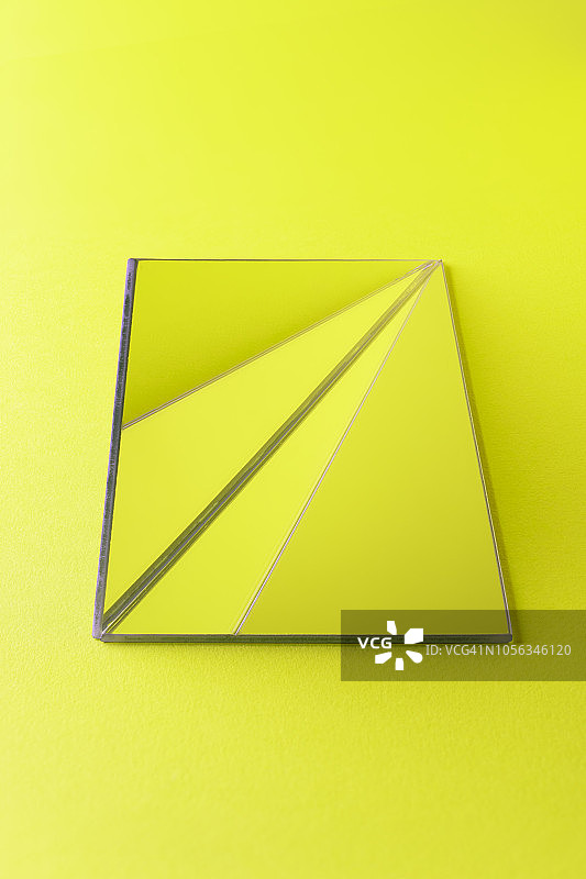 三角形的镜子在石灰绿色的背景图片素材