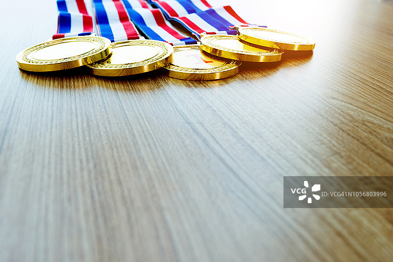 五枚金牌放在木桌上图片素材