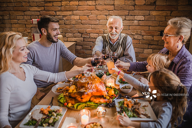 在餐厅举行感恩节晚宴时，祝大家全家敬酒愉快。图片素材